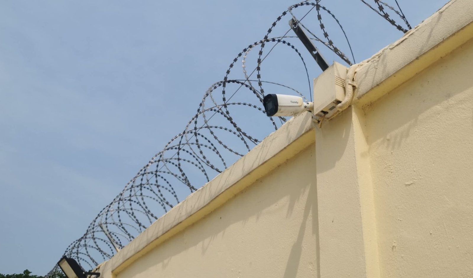 Cámara y alambre de púas en el muro de una residencia